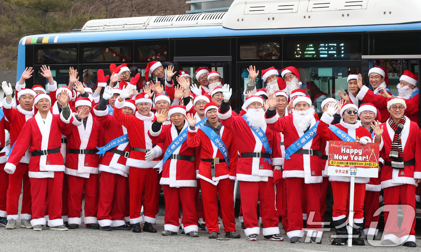 (대구=뉴스1) 공정식 기자 = 크리스마스를 이틀 앞둔 23일 오후 대구 북구 우주교통 차고지에서 열린 산타 발대식에서 산타 복장을 차려입은 시내버스 기사들이 "메리 크리스마스"를 …