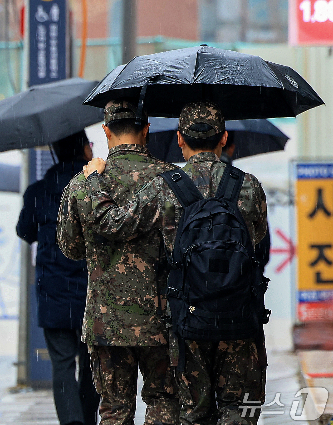 (서울=뉴스1) 이호윤 기자 = 크리스마스 이브를 앞두고 진눈깨비가 내린 23일 서울 종로구 일대에서 군인들이 발걸음을 재촉하고 있다. 2025.12.23/뉴스1