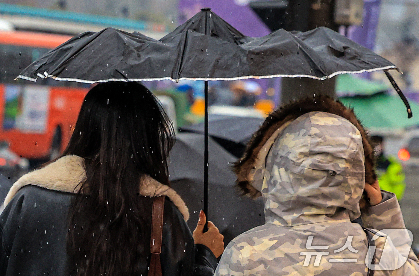 (서울=뉴스1) 이호윤 기자 = 크리스마스 이브를 앞두고 진눈깨비가 내린 23일 서울 종로구 광화문광장에서 우산을 쓴 시민들이 발걸음을 재촉하고 있다. 2025.12.23/뉴스1