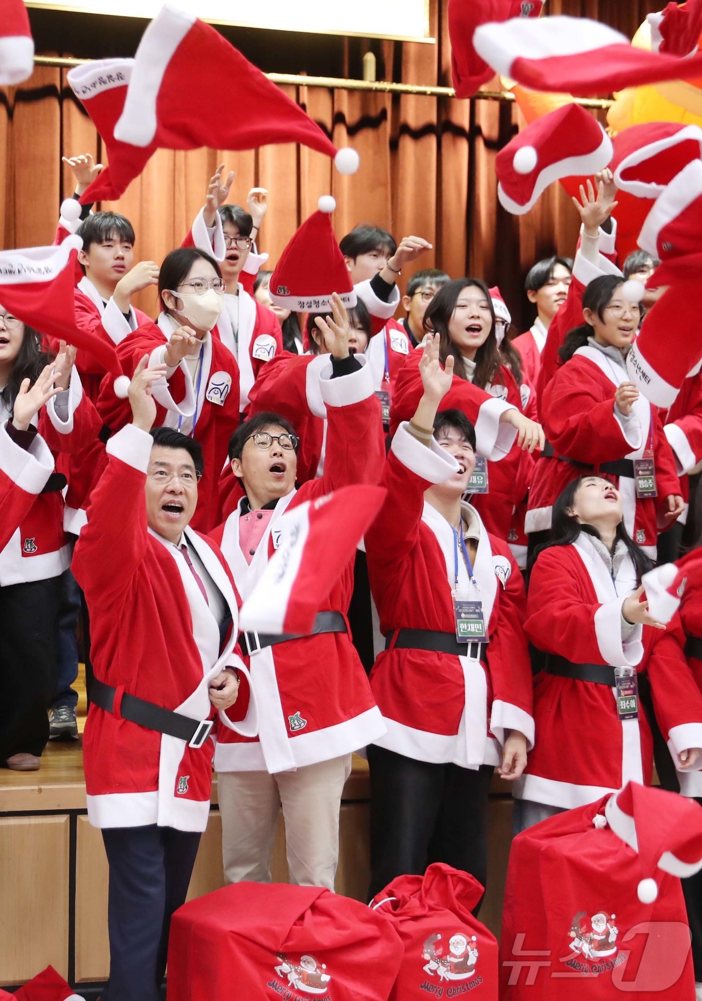 (서울=뉴스1) = 서강석 송파구청장이 23일 구청 대강당에서 열린 잠실산타이즈 커밍 출정식에서 산타 복장을 한 봉사자들과 퍼포먼스를 하고 있다.송파구는 크리스마스를 앞두고 이틀간 …