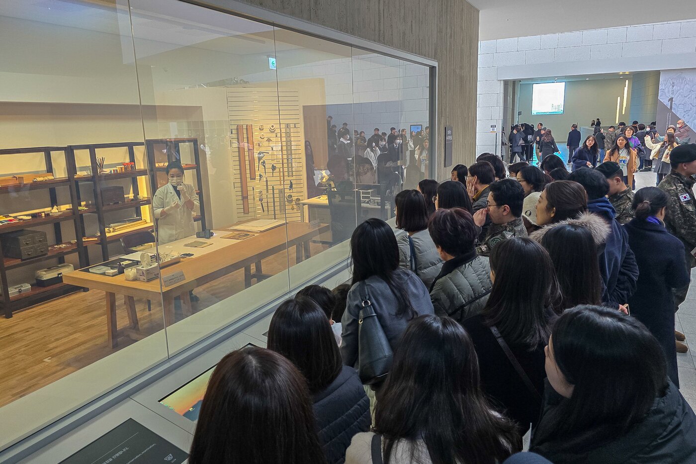 본문 이미지 - 대구간송미술관을 찾은 관람객들이 ‘보이는 수리복원실’에서 수리복원 전문학예사와 질의응답하고 있다. (대구간송미술관 제공)