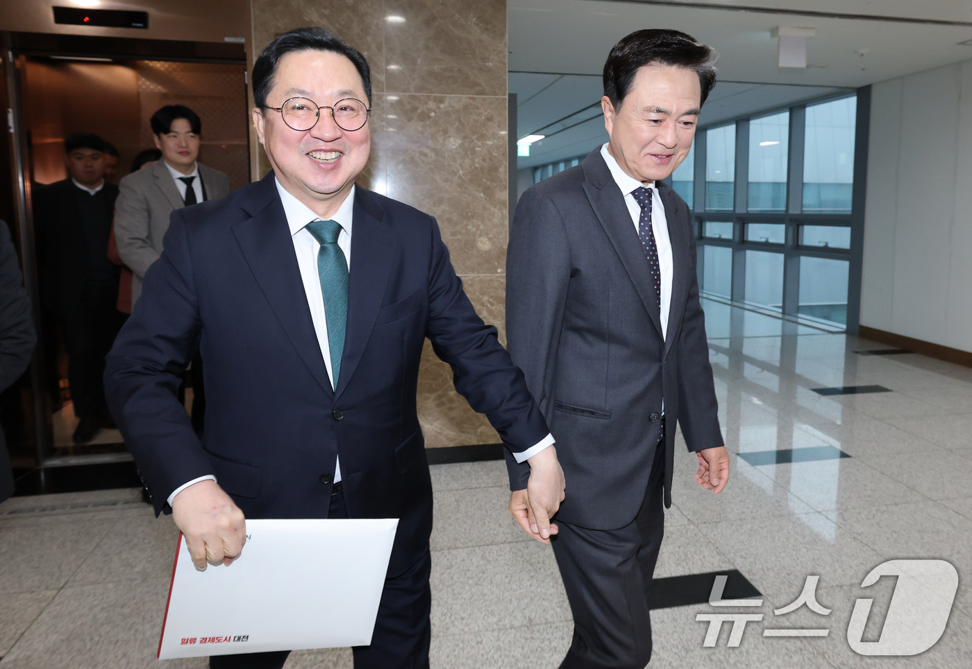 (홍성=뉴스1) 김기태 기자 = 이장우 대전시장과 김태흠 충남도지사가 24일 오전 충남도청에서 대전충남 행정통합 관련 회동에 앞서 손 잡고 회동장으로 이동하고 있다. 2025.12 …