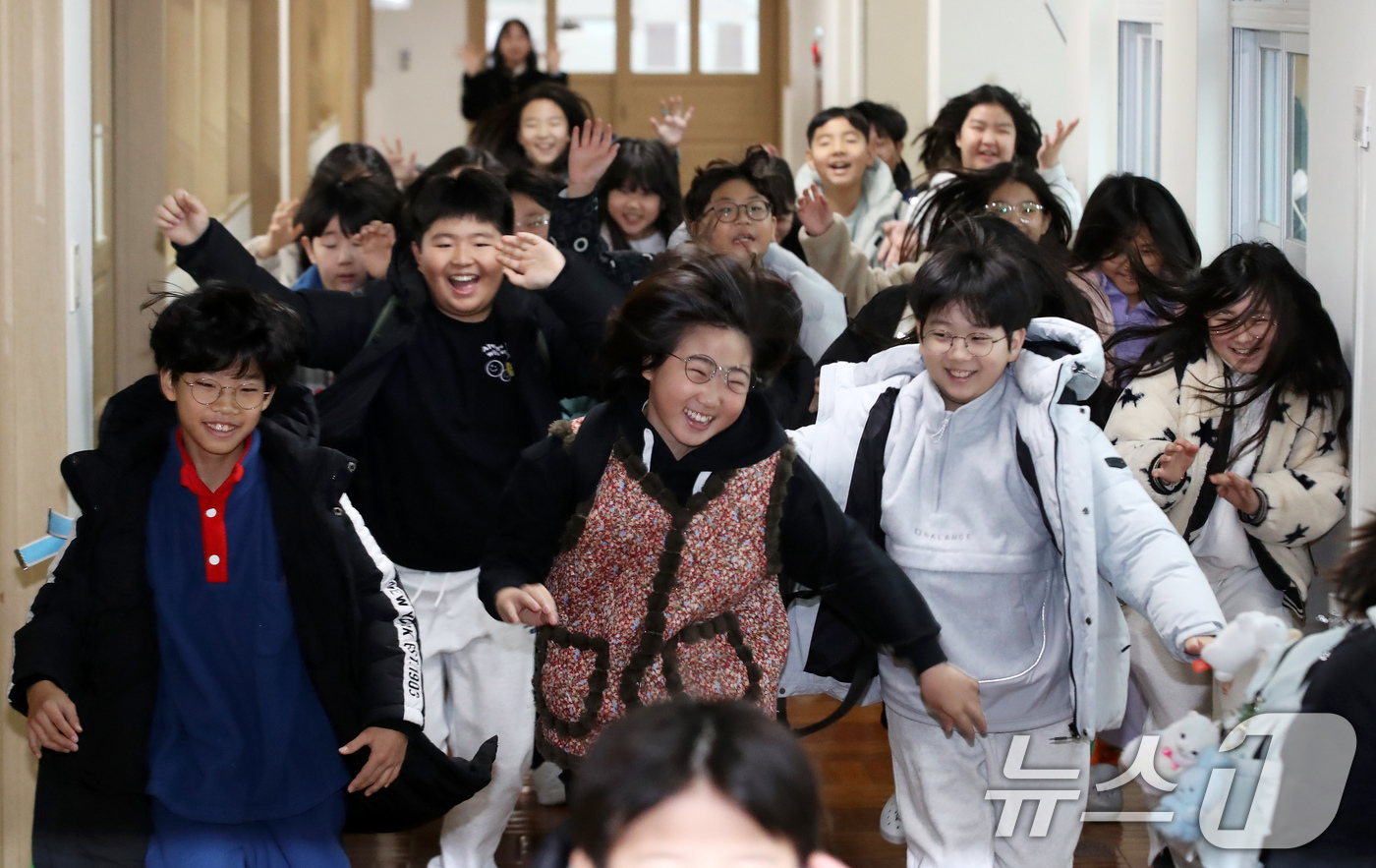 (부산=뉴스1) 윤일지 기자 = 24일 오전 부산 기장군 정관읍 가동초등학교에서 겨울방학을 맞은 4학년 3반 학생들이 환호하며 집으로 향하고 있다.  2025.12.24/뉴스1
