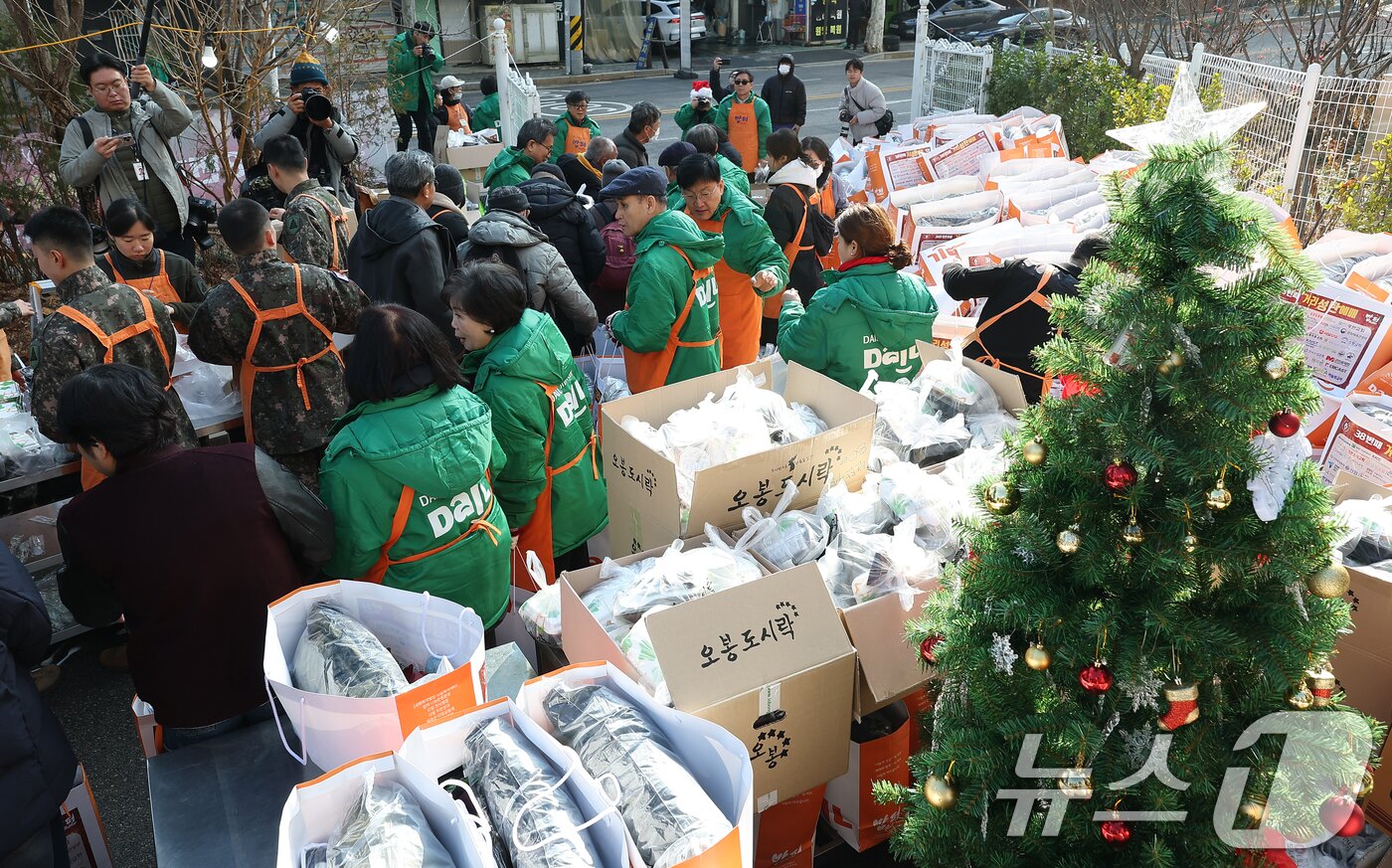 본문 이미지 - 크리스마스를 하루 앞둔 24일 서울 동대문구 밥퍼나눔운동본부에서 열린 '38번째 거리성탄 예배'에서 자원봉사자들이 참가자들에게 음식과 생필품 등을 전달하고 있다. (공동취재) 2025.12.24/뉴스1 ⓒ News1 황기선 기자