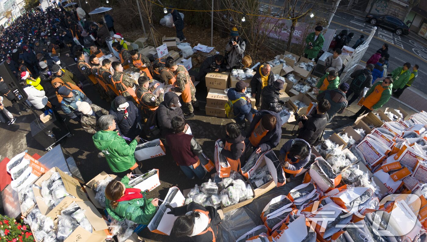 본문 이미지 - 크리스마스를 하루 앞둔 24일 서울 동대문구 밥퍼나눔운동본부에서 열린 '38번째 거리성탄 예배'에서 자원봉사자들이 참가자들에게 음식과 생필품 등을 전달하고 있다. (공동취재) 2025.12.24/뉴스1 ⓒ News1 황기선 기자