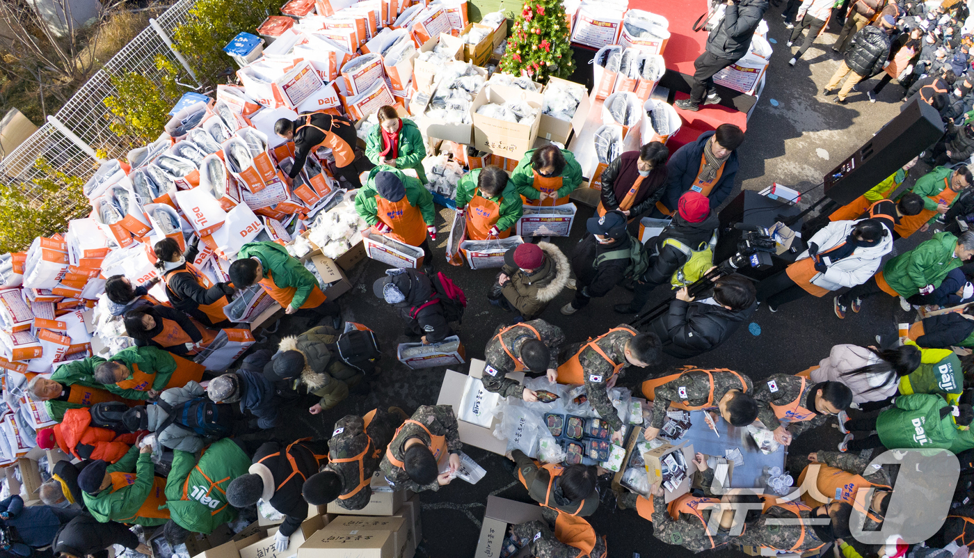 (서울=뉴스1) 황기선 기자 = 크리스마스를 하루 앞둔 24일 서울 동대문구 밥퍼나눔운동본부에서 열린 '38번째 거리성탄 예배'에서 자원봉사자들이 참가자들에게 음식과 생필품 등을 …