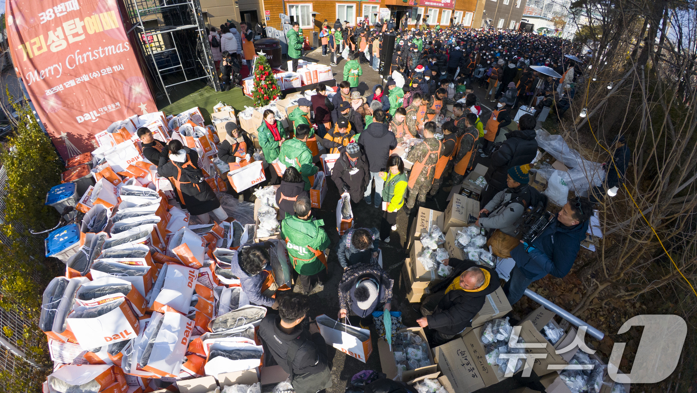 (서울=뉴스1) 황기선 기자 = 크리스마스를 하루 앞둔 24일 서울 동대문구 밥퍼나눔운동본부에서 열린 '38번째 거리성탄 예배'에서 자원봉사자들이 참가자들에게 음식과 생필품 등을 …