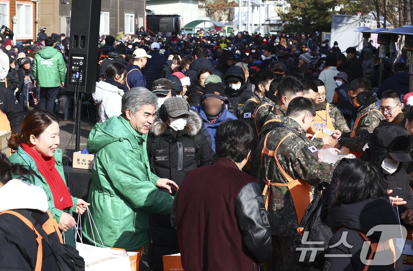 본문 이미지 - 크리스마스를 하루 앞둔 24일 서울 동대문구 밥퍼나눔운동본부에서 열린 '38번째 거리성탄 예배'에서 자원봉사자들이 참가자들에게 음식과 생필품 등을 전달하고 있다. (공동취재) 2025.12.24/뉴스1 ⓒ News1 황기선 기자