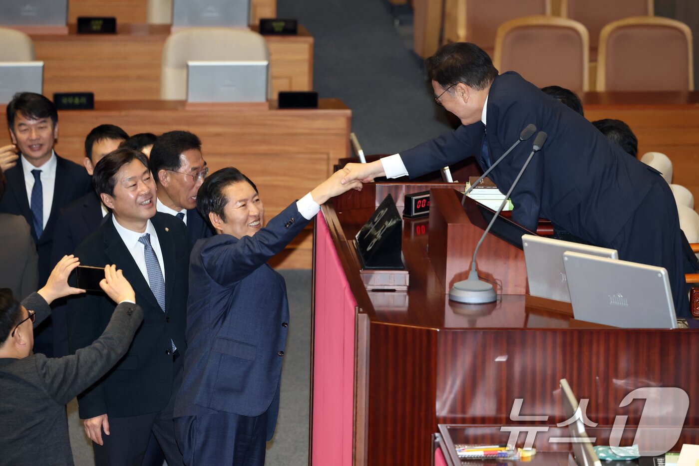 본문 이미지 - 정청래 더불어민주당 대표가 23일 서울 여의도 국회에서 열린 제430회국회(임시회) 제2차 본회의에서 정보통신망 이용촉진 및 정보보호 등에 관한 법률 일부개정법률안(대안) 수정안에 대한 무제한 토론(필리버스터) 종결동의의 건 투표를 하고 우원식 국회의장과 악수하고 있다. 2025.12.24/뉴스1 ⓒ News1 이승배 기자