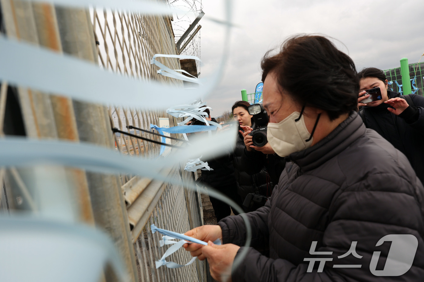 (무안=뉴스1) 박지현 기자 = 12·29 제주항공 여객기 참사 1주기를 앞둔 24일 전남 무안국제공항에서 아들을 떠나보낸 이경임 씨가 추모 리본을 달고 있다. 2025.12.24 …