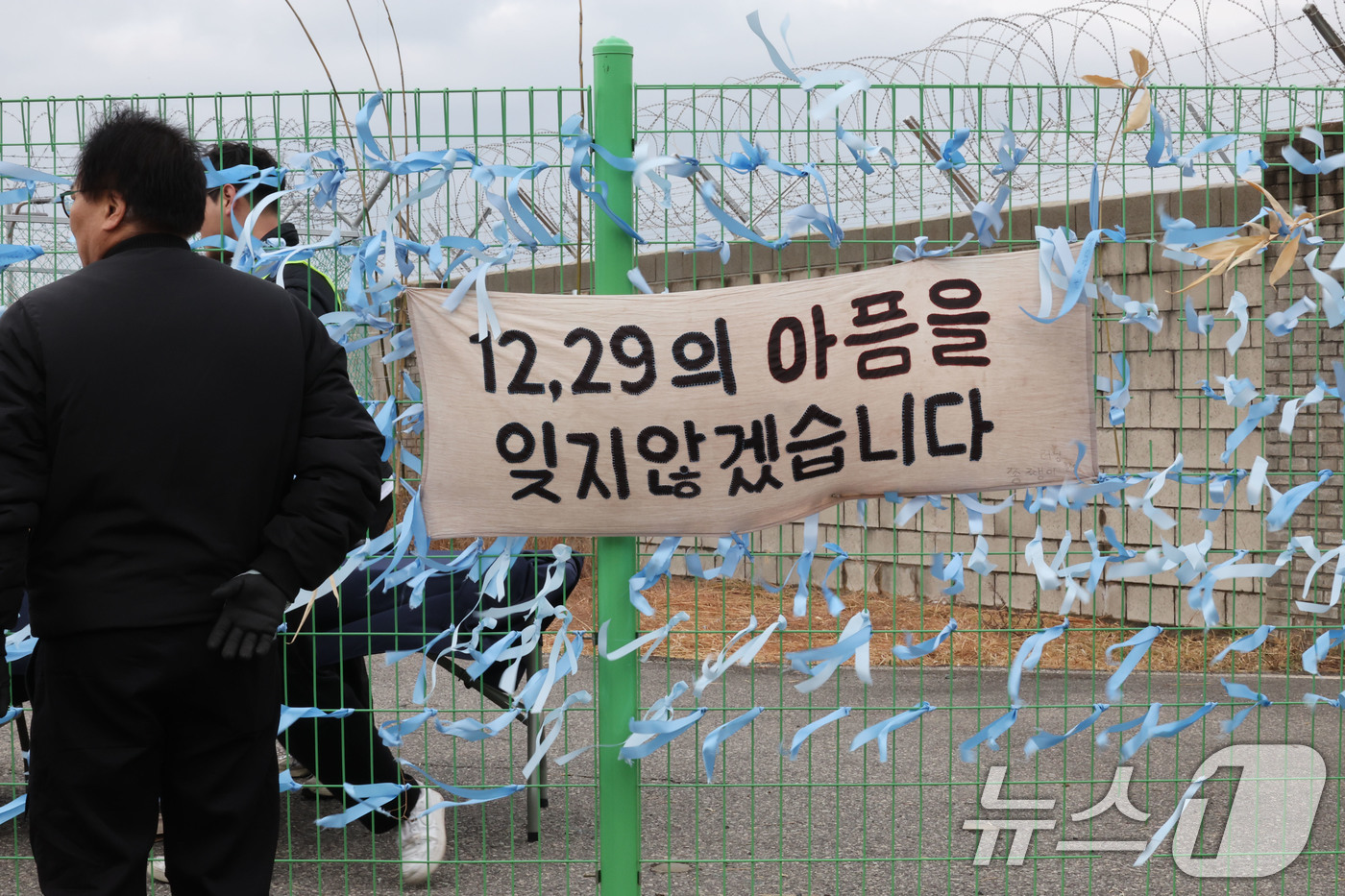 (무안=뉴스1) 박지현 기자 = 12·29 제주항공 여객기 참사 1주기를 앞둔 24일 전남 무안국제공항에서 시민들이 추모 리본을 작성해 달고 있다.  2025.12.24/뉴스1