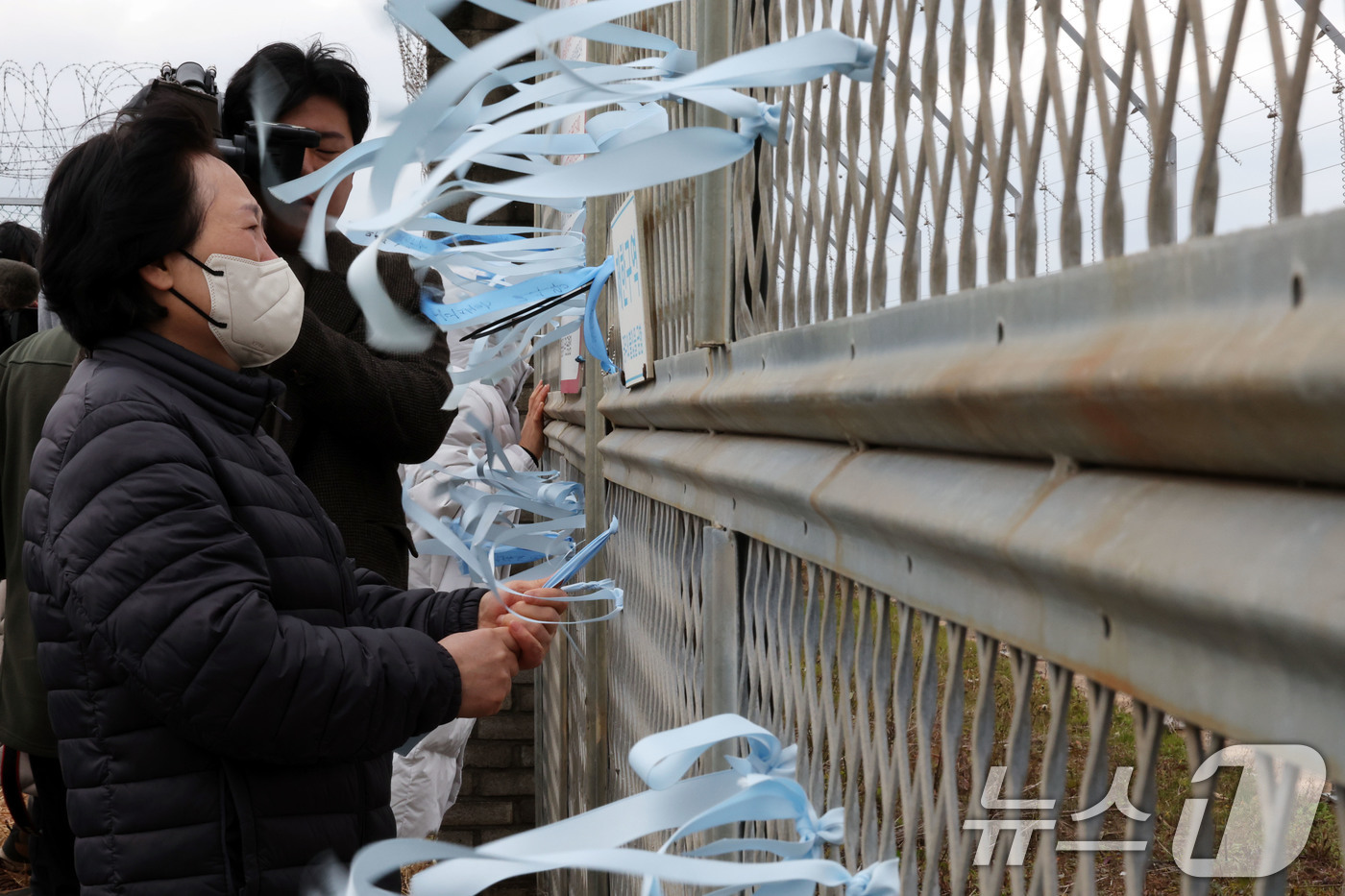 (무안=뉴스1) 박지현 기자 = 12·29 제주항공 여객기 참사 1주기를 앞둔 24일 전남 무안국제공항에서 유가족 이경임 씨가 추모 리본을 작성해 달고 있다.  2025.12.24 …