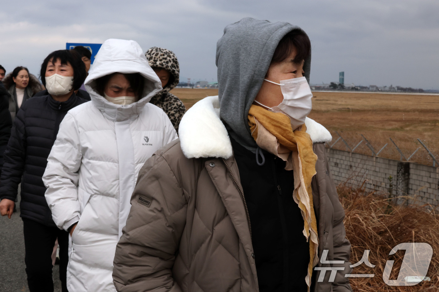 (무안=뉴스1) 박지현 기자 = 12·29 제주항공 여객기 참사 1주기를 앞둔 24일 전남 무안국제공항 순례길에서 유가족들이 활주로를 바라보며 눈물을 흘리고 있다.  2025.12 …