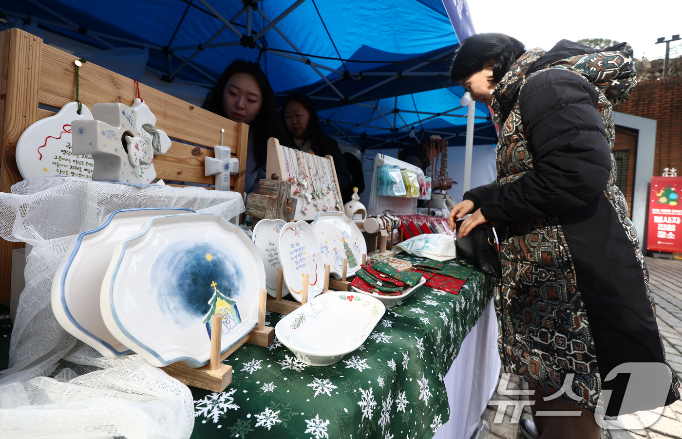 (서울=뉴스1) 김민지 기자 = 크리스마스 이브인 24일 오후 서울 중구 명동성당 앞에서 열린 크리스마스 마켓에서 시민들이 성탄절 장식을 살펴보고 있다. 2025.12.24/뉴스1 …