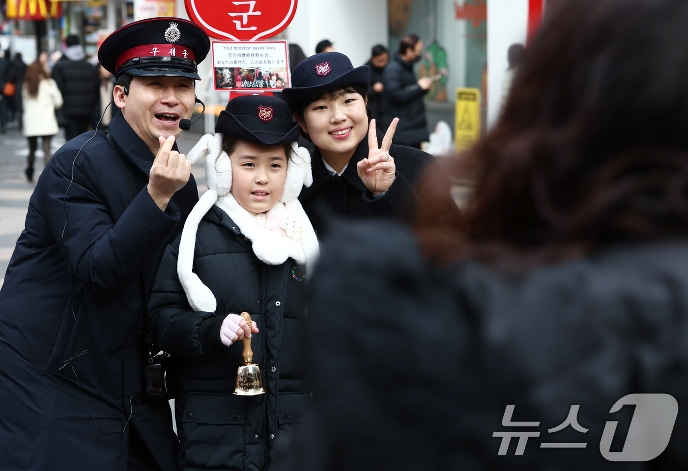 (서울=뉴스1) 김민지 기자 = 크리스마스 이브인 24일 오후 서울 중구 명동거리에서 한 어린이가 구세군 자선냄비에 기부한 후 사진을 찍고 있다. 2025.12.24/뉴스1