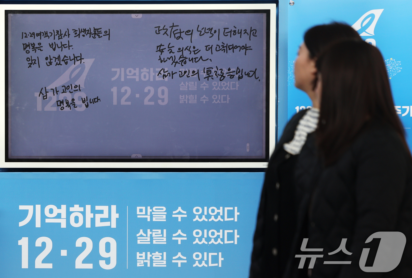 (서울=뉴스1) 황기선 기자 = 12·29 무안공항 제주항공 여객기 참사 1주기를 앞둔 24일 오후 서울역에 마련된 디지털 분향소에 추모 글귀가 적혀 있다.  2025.12.24/ …