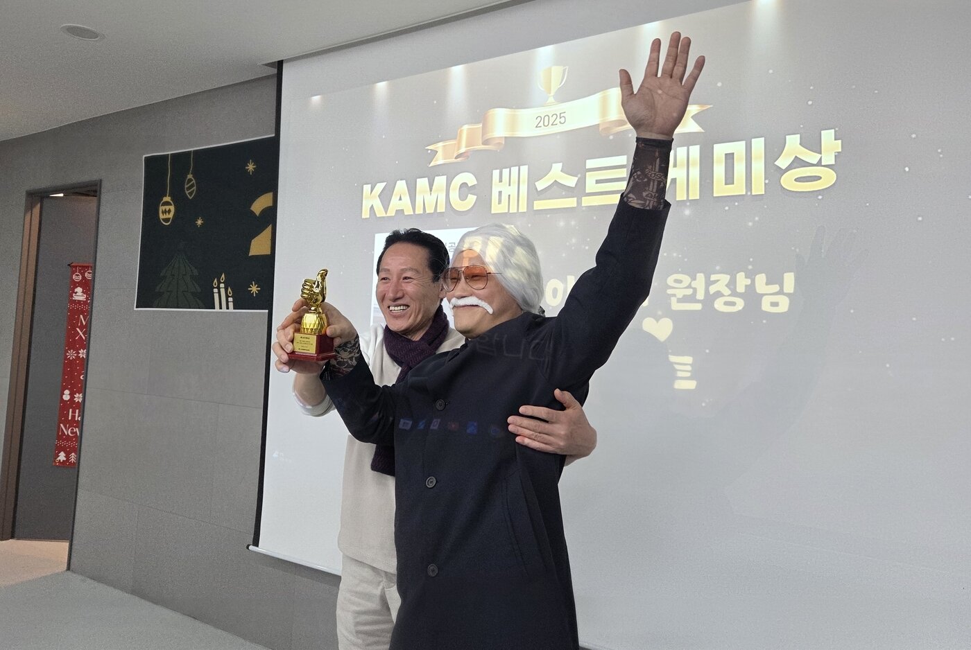 본문 이미지 - 종무식 공연을 위해 분장한 이선태 고려동물메디컬센터 원장(오른쪽)이 동물병원을 찾은 동물과 남다른 교감을 보여준 직원에게 주는 '베스트 케미상'을 받고 이승근 대표원장과 기념 사진을 찍고 있다. ⓒ 뉴스1 한송아 기자