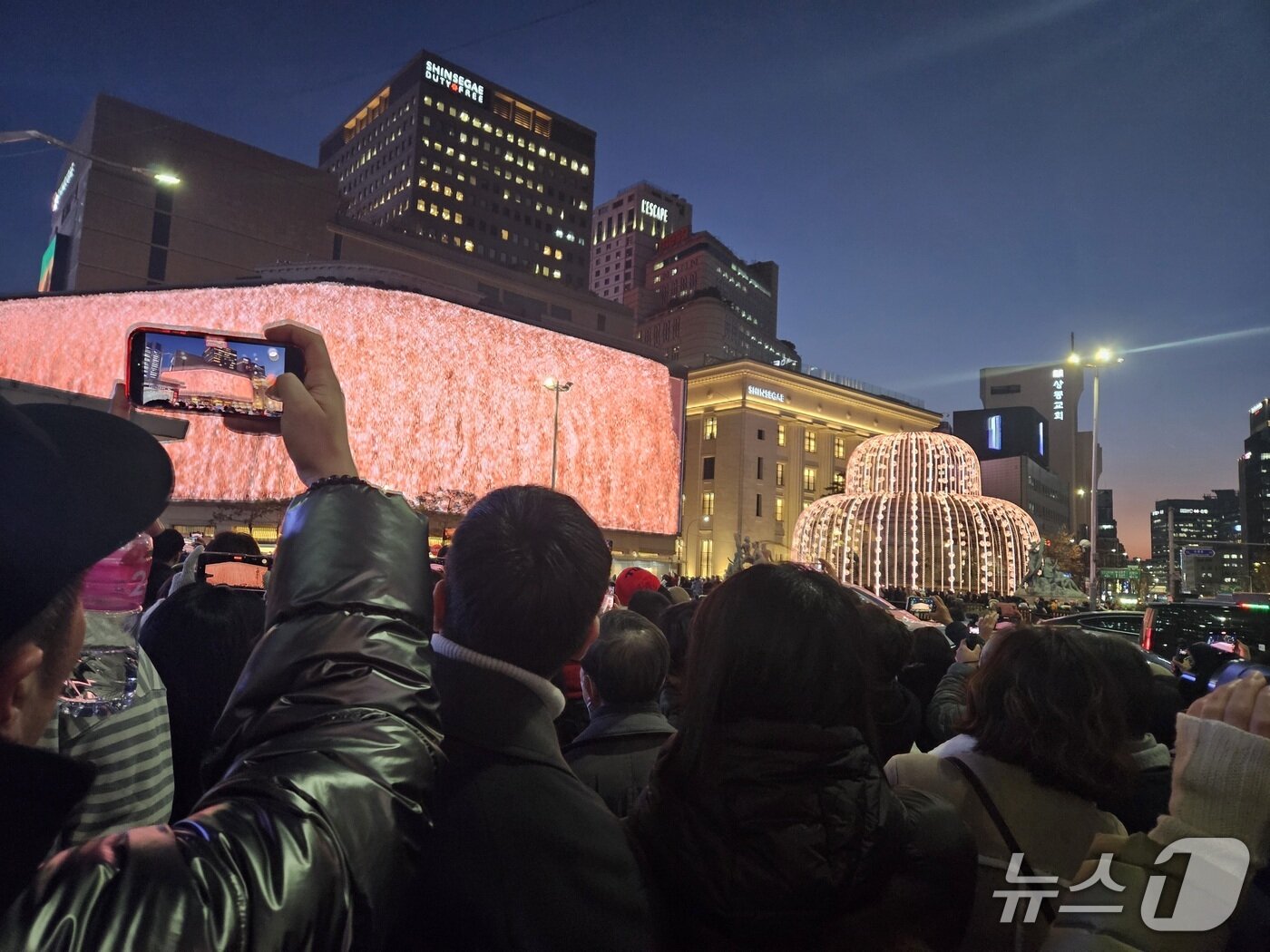 본문 이미지 - 성탄절 이브인 24일 저녁 서울 중구 명동 서울중앙우체국 앞은 신세계백화점 미디어파사드를 보기 위해 몰린 인파로 북적였다. 2025.12.24/뉴스1 ⓒ News1 유채연 기자