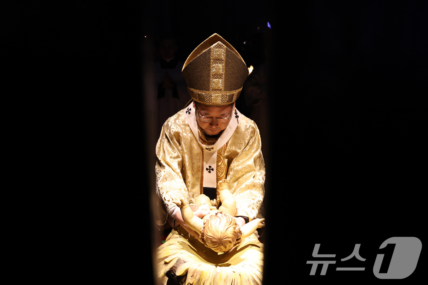 (서울=뉴스1) 구윤성 기자 = 천주교 서울대교구장 정순택 대주교가 25일 새벽 서울 중구 명동대성당 앞마당에서 아기 예수를 말 구유에 안치하는 '구유 예절' 의식을 행하고 있다. …