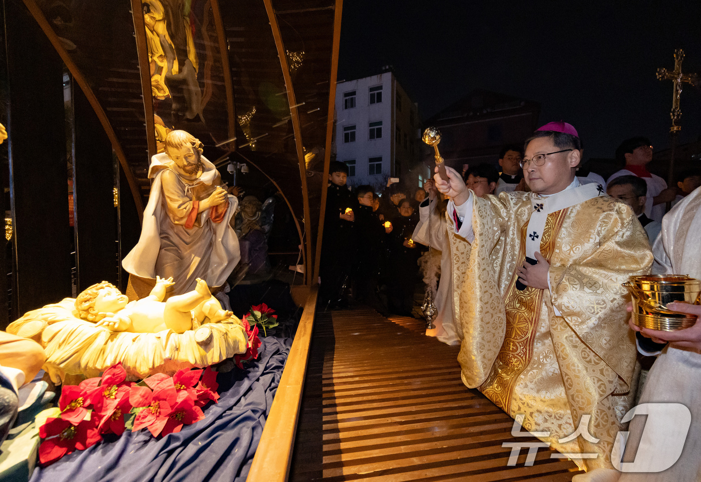 (서울=뉴스1) 구윤성 기자 = 천주교 서울대교구장 정순택 대주교가 성탄절인 25일 새벽 서울 중구 명동대성당 앞마당에서 아기 예수를 말 구유에 안치하는 '구유 예절' 의식을 행하 …