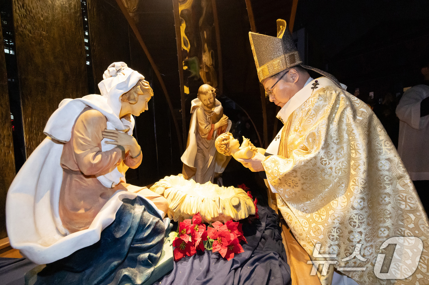 (서울=뉴스1) 구윤성 기자 = 천주교 서울대교구장 정순택 대주교가 성탄절인 25일 새벽 서울 중구 명동대성당 앞마당에서 아기 예수를 말 구유에 안치하는 '구유 예절' 의식을 행하 …