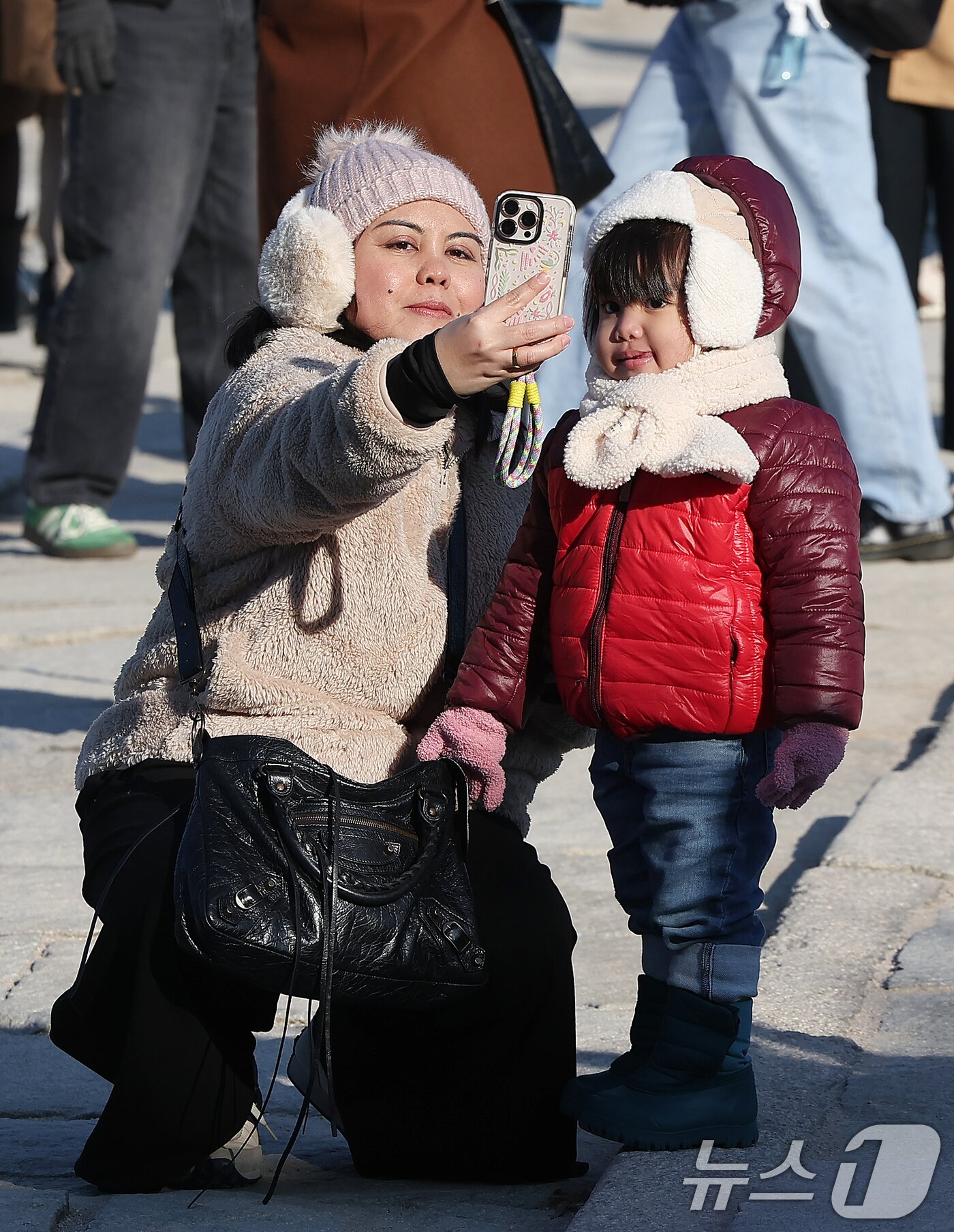 본문 이미지 - 서울과 경기에 한파주의보가 내려진 25일 서울 종로구 경복궁을 찾은 외국인 관광객들이 추억을 남기고 있다. 2025.12.25/뉴스1 ⓒ News1 김진환 기자