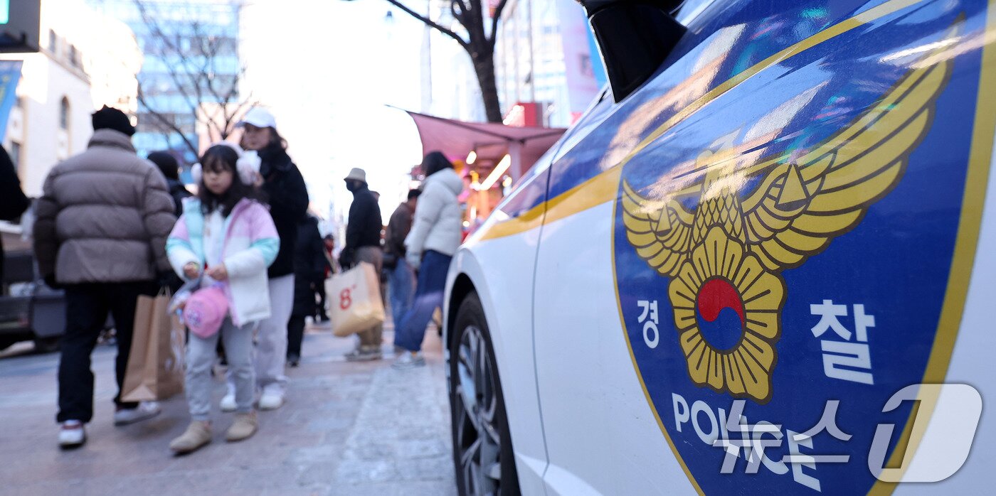 본문 이미지 - 크리스마스인 25일 인파가 몰린 서울 명동 거리에 경찰차가 세워져 있다. 경찰은 연말연시를 맞아 주요 관광지와 축제장 등 다중 인파가 예상되는 지역에 경력을 집중 배치하고 있다. 서울경찰청은 다중운집지역 34곳에 기동순찰대 340명을 배치했다고 지난 24일 밝혔다. 2025.12.25/뉴스1 ⓒ News1 박지혜 기자