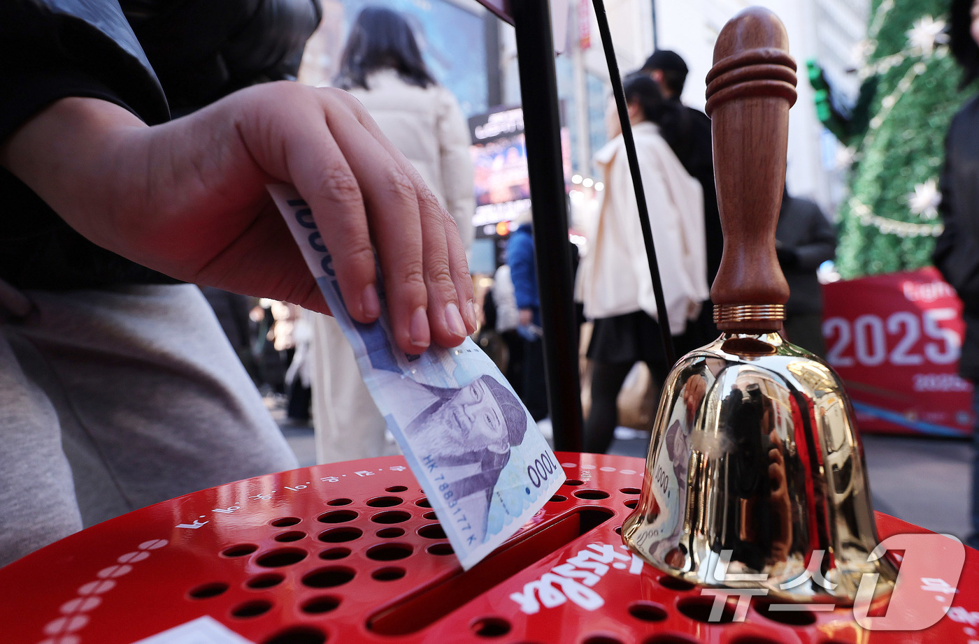 (서울=뉴스1) 박지혜 기자 = 크리스마스인 25일 서울 명동거리에 설치된 구세군 자선냄비에 한 시민이 기부금을 넣고 있다. 2025.12.25/뉴스1