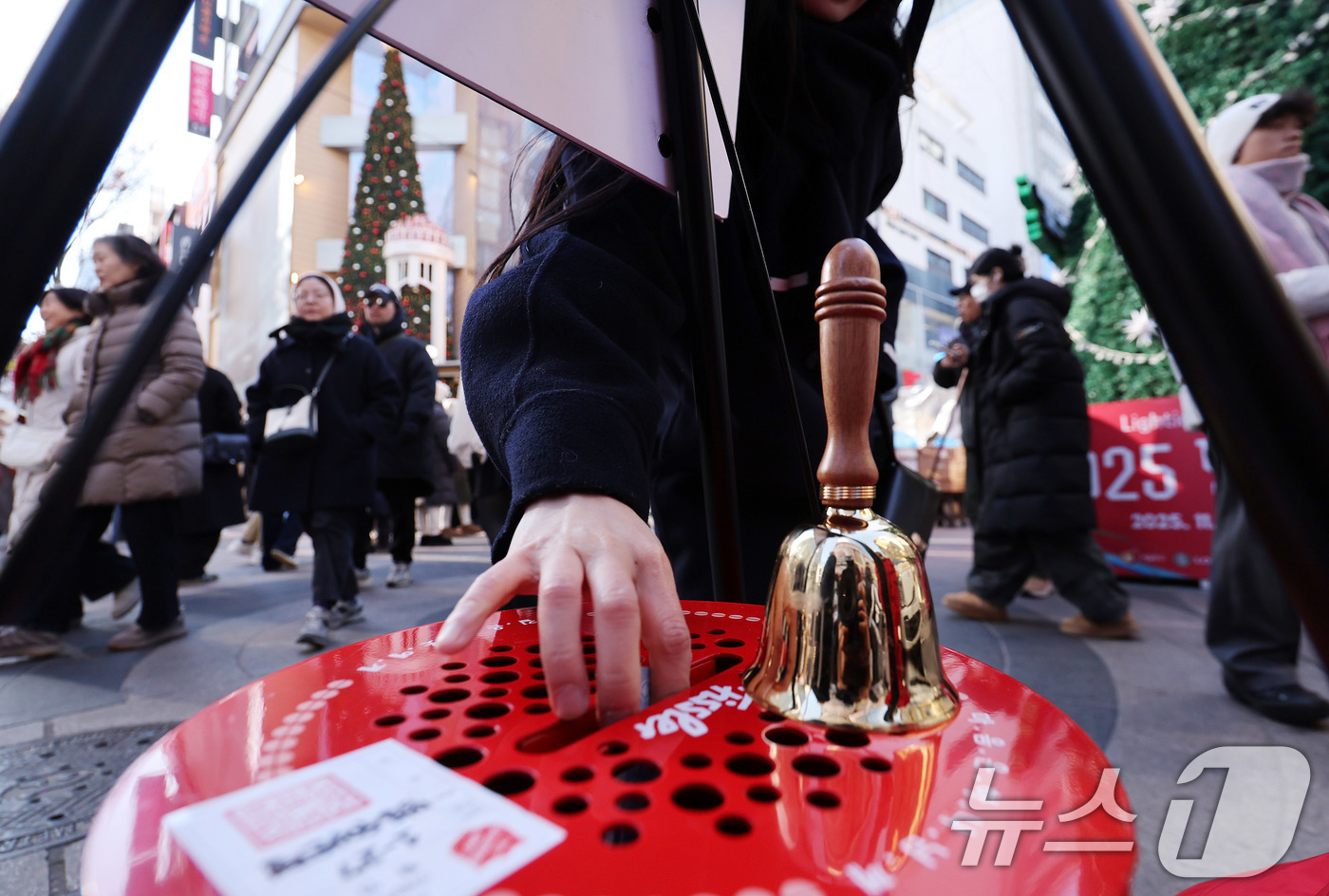 (서울=뉴스1) 박지혜 기자 = 크리스마스인 25일 서울 명동거리에 설치된 구세군 자선냄비에 한 시민이 기부금을 넣고 있다. 2025.12.25/뉴스1