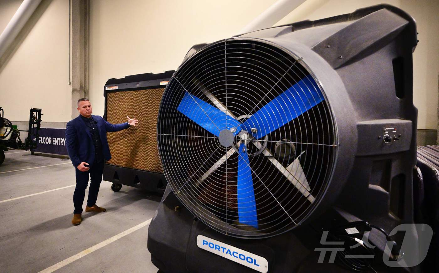 본문 이미지 - 9일(현지시간) 미국 로스앤젤레스 소파이 스타디움에서 시설·캠퍼스 운영 담당 수석 부사장 오토 베네딕트가 포타쿨 증발식 냉각기가 탑재된 대형 선풍기를 소개하고 있다. 2025.12.09. ⓒ AFP=뉴스1 ⓒ News1 이정환 기자