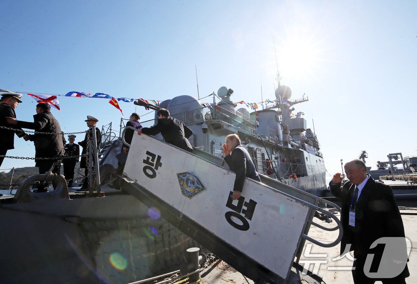 본문 이미지 - 26일 경남 창원 진해구 진해 군항에서 열린 국산 초계함 광명함(PCC·1000톤급) 전역식에서 역대 함장들이 광명함에 오르며 경례하고 있다. 2025.12.26/뉴스1 ⓒ News1 윤일지 기자