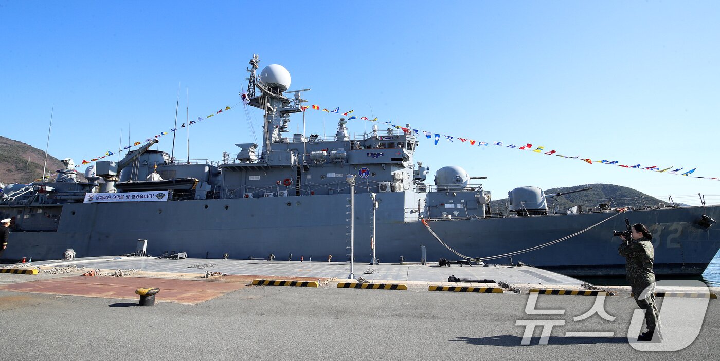 본문 이미지 - 26일 경남 창원 진해구 진해 군항에서 국산 초계함 광명함(PCC·1000톤급) 전역식이 열린 가운데 해군 관계자가 광명함의 마지막 모습을 카메라에 담고 있다.  2025.12.26/뉴스1 ⓒ News1 윤일지 기자