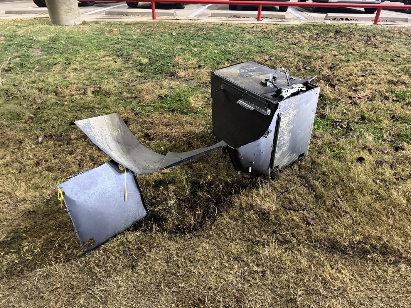 본문 이미지 - 용의자들이 ATM을 주차장 밖으로 끌어내 도주하는 과정에서 ATM이 금속 케이블에서 분리됐다. 경찰은 ATM 내 현금을 모두 회수할 수 있었다. (출처=크리스토퍼 쿡 화이트세틀먼트 경찰국장)