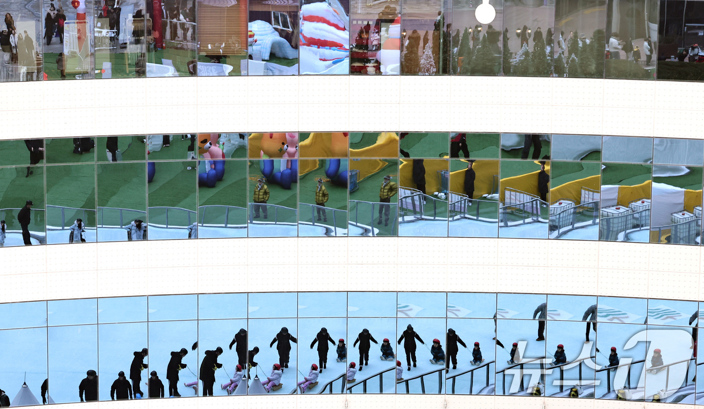 (서울=뉴스1) 구윤성 기자 = 28일 오후 서울 송파구 가든파이브 중앙광장에 마련된 '2025 하하호호 눈썰매장'에서 시민들이 얼음썰매를 즐기는 모습이 쇼핑몰 창가에 비치고 있다 …
