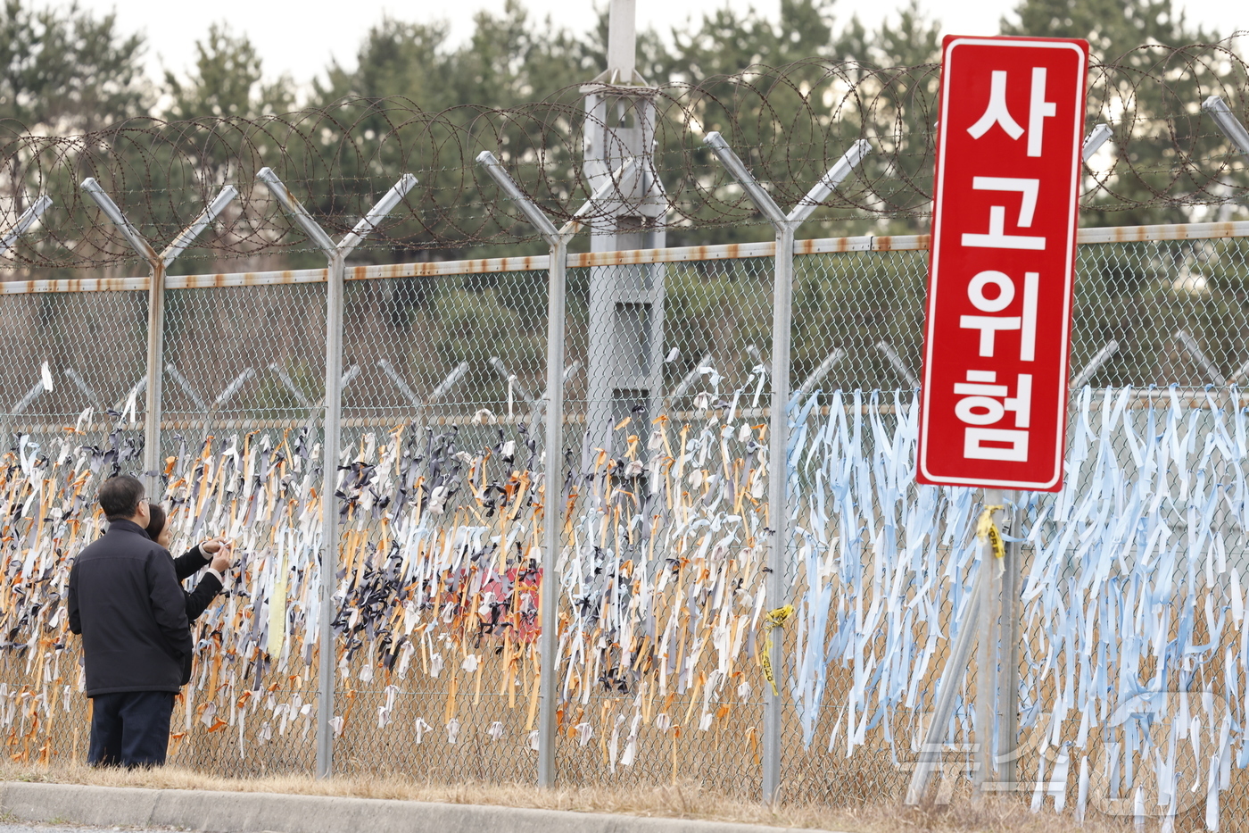 (무안=뉴스1) 김태성 기자 = 12·29 여객기 참사 1주기를 하루 앞둔 28일 전남 무안국제공항 활주로 인근에서 시민들이 179명의 희생자의 넋을 기리는 파란 리본을 부착하고 …