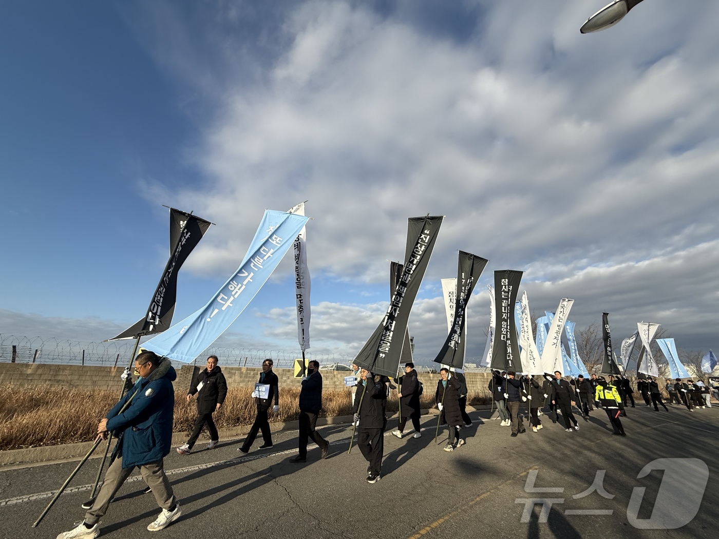 (무안=뉴스1) 김태성 기자 = 12·29 여객기 참사 1주기를 하루 앞둔 28일 오후 참사 유가족들과 시민들이 무안국제공항 외곽도로에서 로컬라이저까지 만장행진을 통해 '진상규명' …