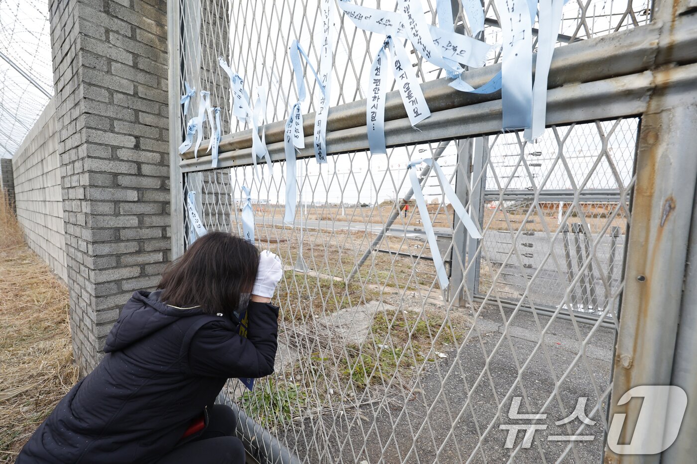 본문 이미지 - 12·29 여객기 참사 1주기를 하루 앞둔 28일 오후 무안국제공항 참사현장에서 만장행진을 마친 유가족들이 현장을 지켜보며 눈물을 흘리고 있다. 2025.12.28/뉴스1 ⓒ News1 김태성 기자
