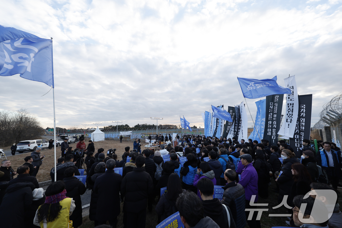 (무안=뉴스1) 김태성 기자 = 12·29 여객기 참사 1주기를 하루 앞둔 28일 무안국제공항 참사현장앞에서 만장행진을 한 유가족들과 시민들이 희생자들을 위해 기도를 올리고 있다. …