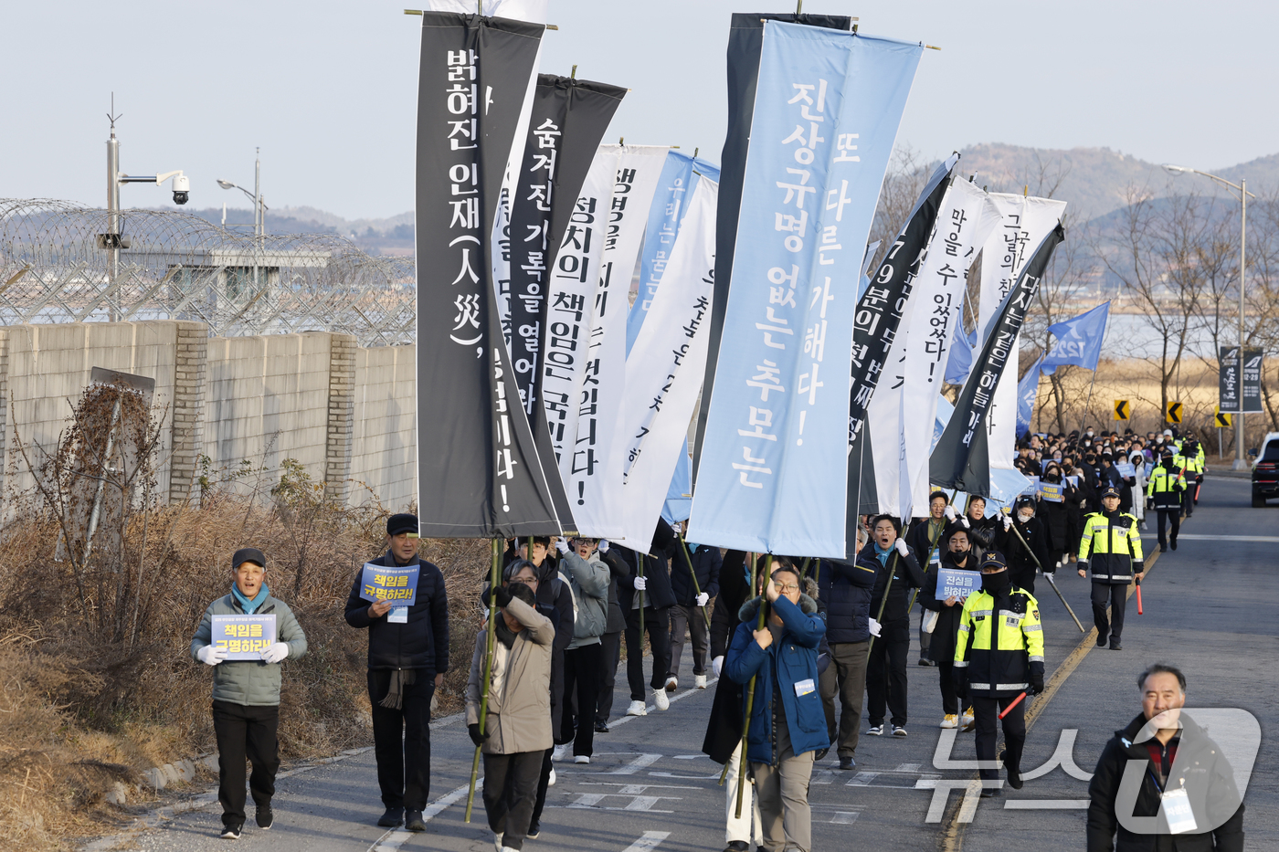 (무안=뉴스1) 김태성 기자 = 12·29 여객기 참사 1주기를 하루 앞둔 28일 참사 유가족들과 시민들이 무안국제공항에서 사고현장 로컬라이저까지 만장행진을 통해 '진상규명'을 촉 …