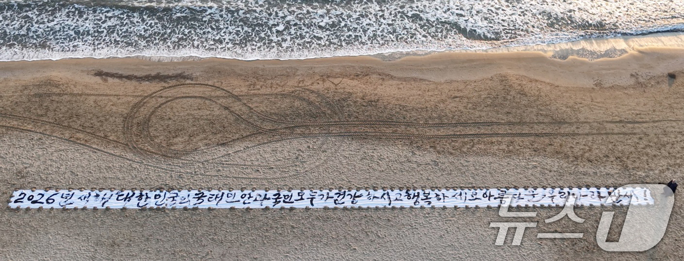 (포항=뉴스1) 최창호 기자 = 독도 서예가 김동욱 씨가 26일 오전 경북 포항시 송도해수욕장 백사장에서 길이 50m 광목천에 2026년 병오년 한해도 국민의 행복을 기원하는 글귀 …
