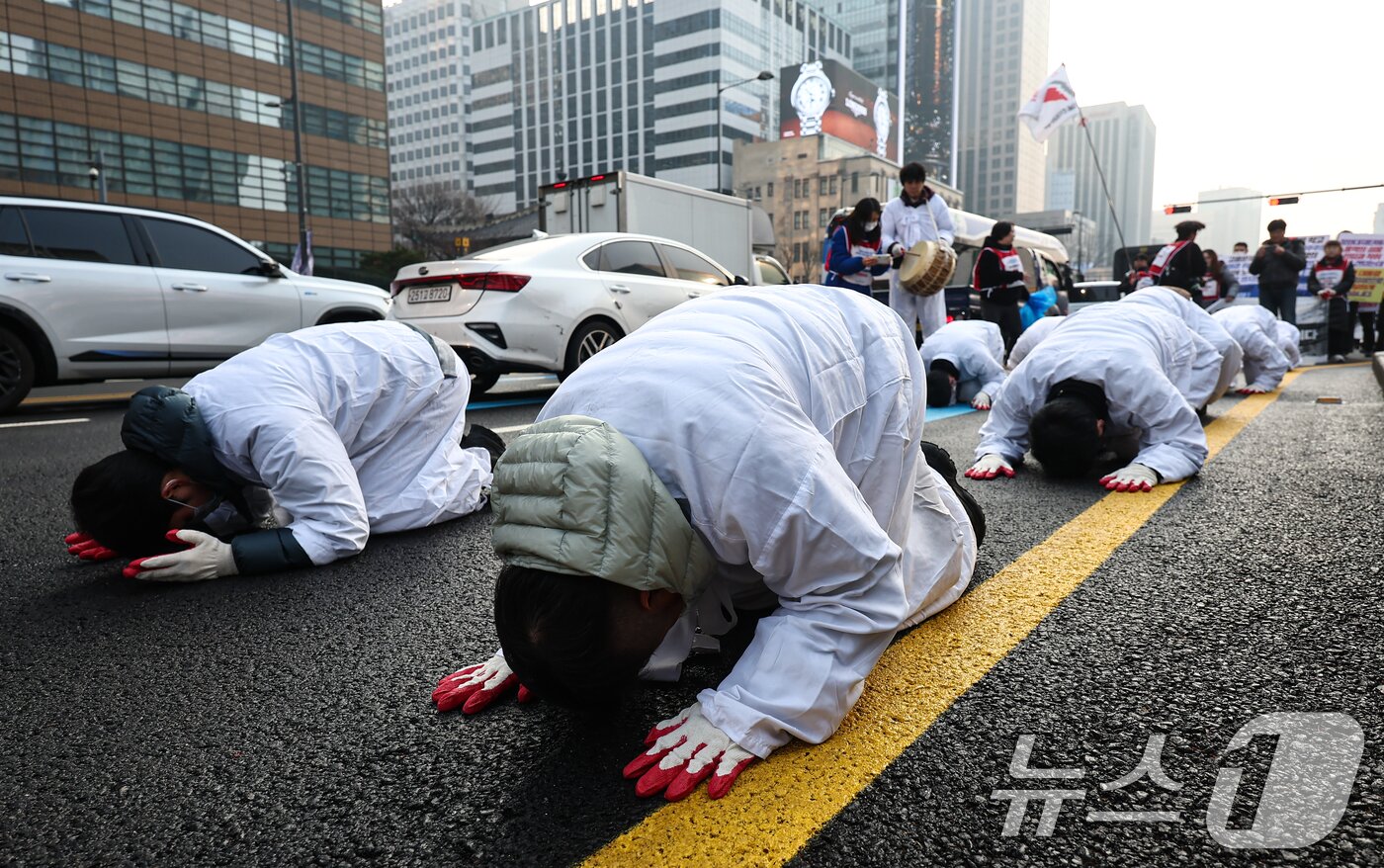 본문 이미지 - 공공운수노조 서울지역공공서비스지부 조합원들이 29일 서울 광화문 광장에서 청와대 비정규직 고용보장을 촉구하며 청와대 방면으로 삼보일배 하고 있다. 2025.12.29/뉴스1 ⓒ News1 김도우 기자