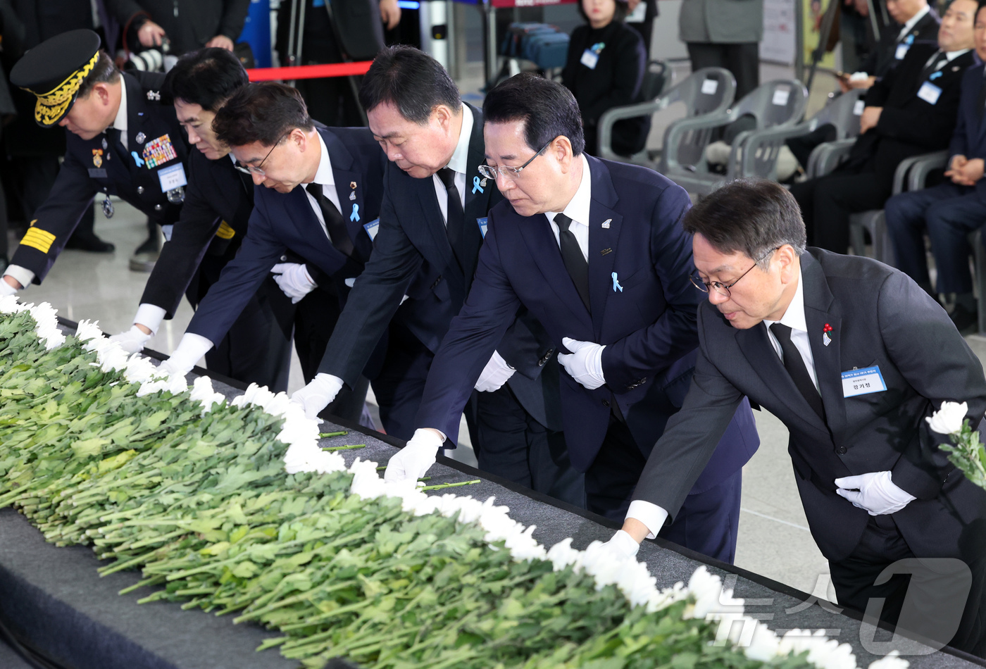 (무안=뉴스1) 사진공동취재단 = 29일 오전 전남 무안국제공항에서 열린 12·29 제주항공 여객기 참사 1주기 추모식에서 김영록 전남지사와 강기정 광주시장를 비롯한 참석자들이 헌 …