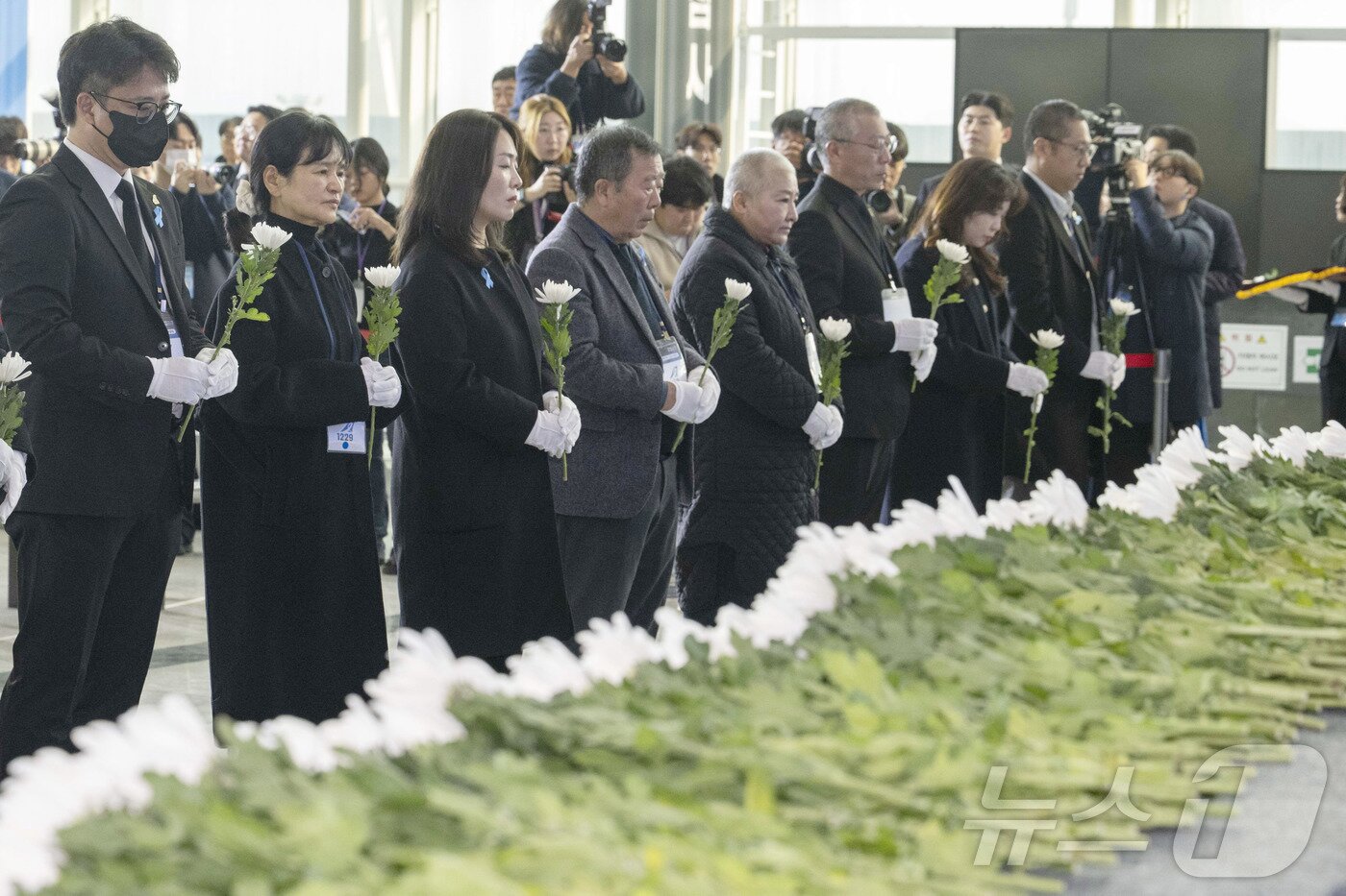 본문 이미지 - 29일 오전 무안국제공항에서 열린 '12.29 제주항공 여객기 참사 1주기 추모식'에서 김유진 유가족협의회 대표를 비롯한 유가족들이 희생자들을 기리며 묵념하고 있다. 2025.12.29/뉴스1 ⓒ News1 사진공동취재단