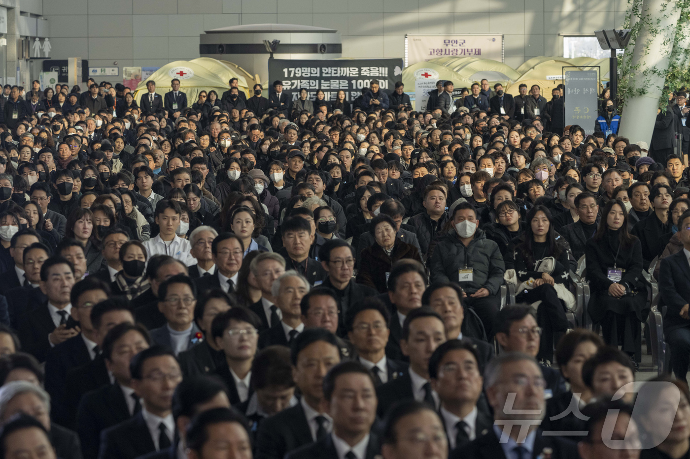 (무안=뉴스1) 사진공동취재단 = 12.29 제주항공 여객기 참사 1주기인 29일 오전 전남 무안국제공항에서 추모식이 엄수되고 있다. 추모식에 참석한 시민들이 침통한 표정으로 추모 …
