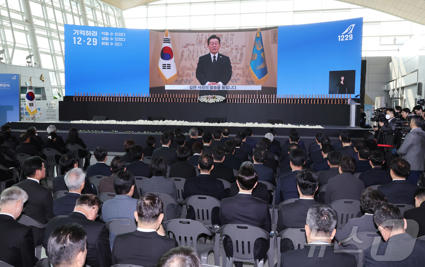 (무안=뉴스1) 사진공동취재단 = 12·29 제주항공 여객기 참사 1주기인 29일 오전 전남 무안국제공항에서 추모식에서 이재명 대통령의 영상 추모사가 공개되고 있다.  2025.1 …