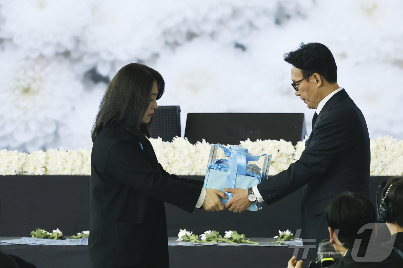 (무안=뉴스1) 김태성 기자 = 12·29 제주항공 여객기 참사 1주기인 29일 오전 전남 무안국제공항에서 열림 추모식에서 김유진 유가족협의회 대표가 김민석총리에게 유족들의 메시지 …