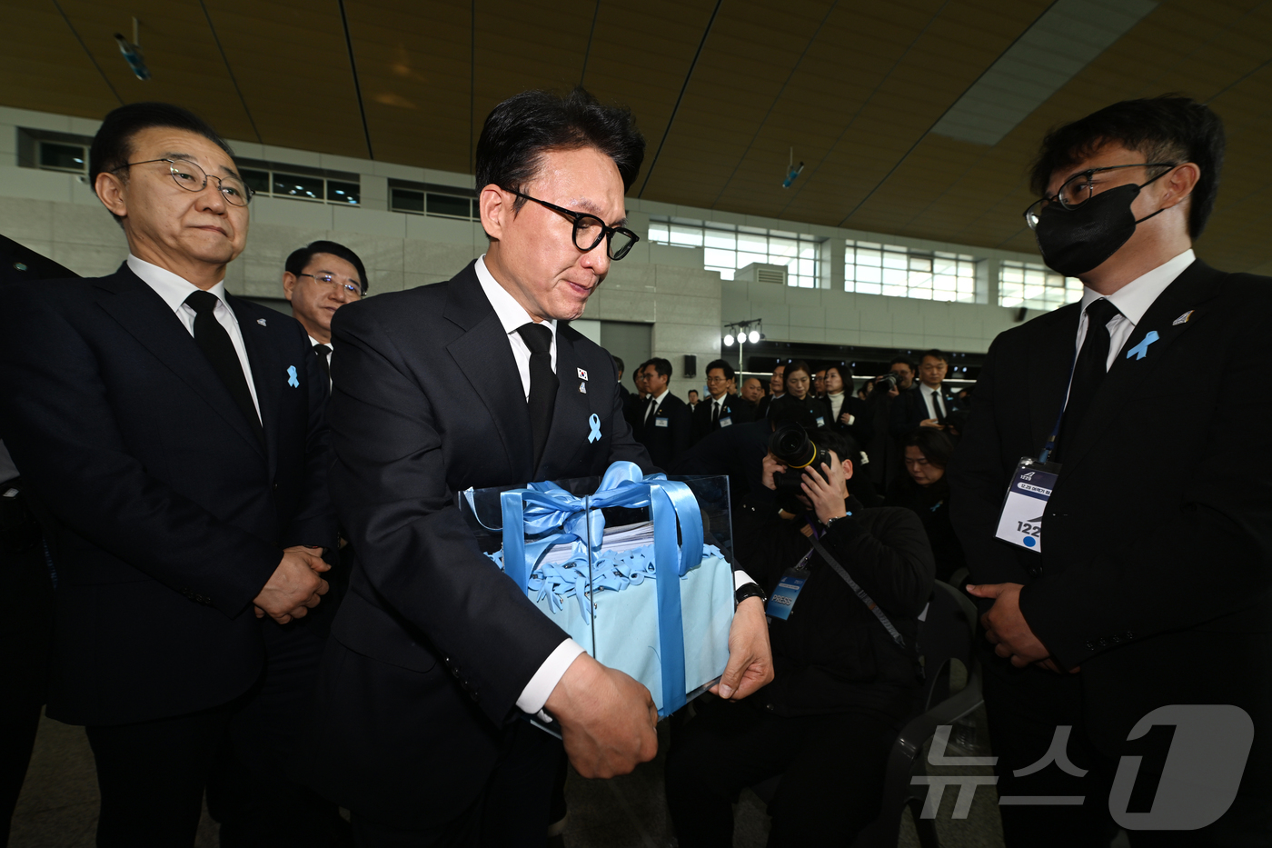 (무안=뉴스1) 사진공동취재단 = 김민석 국무총리가 29일 오전 전남 무안군 무안국제공항에서 열린 12·29 제주항공 참사 추모식에 참석해 유가족들로부터 전달받은 진상규명·재발방지 …