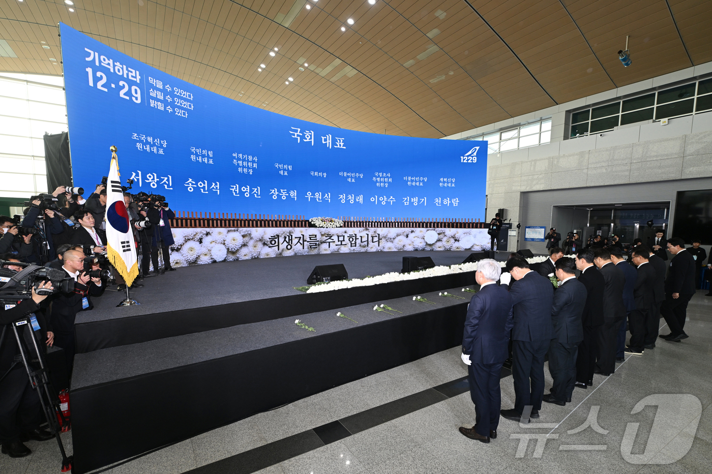 (무안=뉴스1) 사진공동취재단 = 12·29 제주항공 여객기 참사 1주기인 29일 오전 전남 무안군 무안국제공항에서 열린 추모식 도중 국회 대표단이 제단에 헌화하고 있다. 왼쪽부터 …