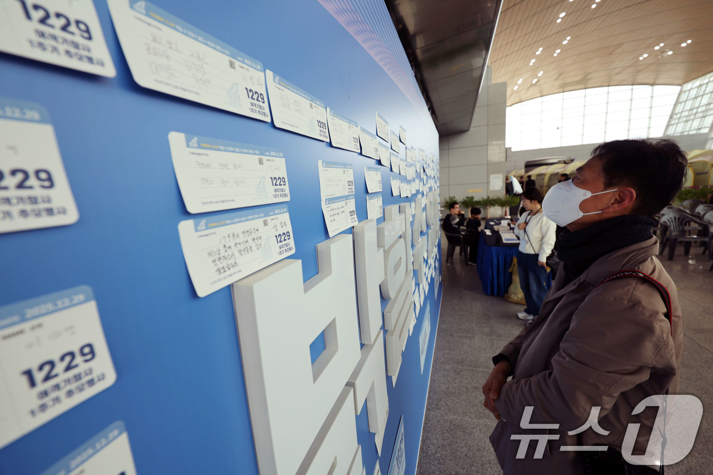 (무안=뉴스1) 박지현 기자 = 12·29 여객기 참사 1주기인 29일 전남 무안국제공항 내 추모의벽에서 시민들이 탑승권 형식의 추모메시지를 읽으며 추모하고 있다.  2025.12 …