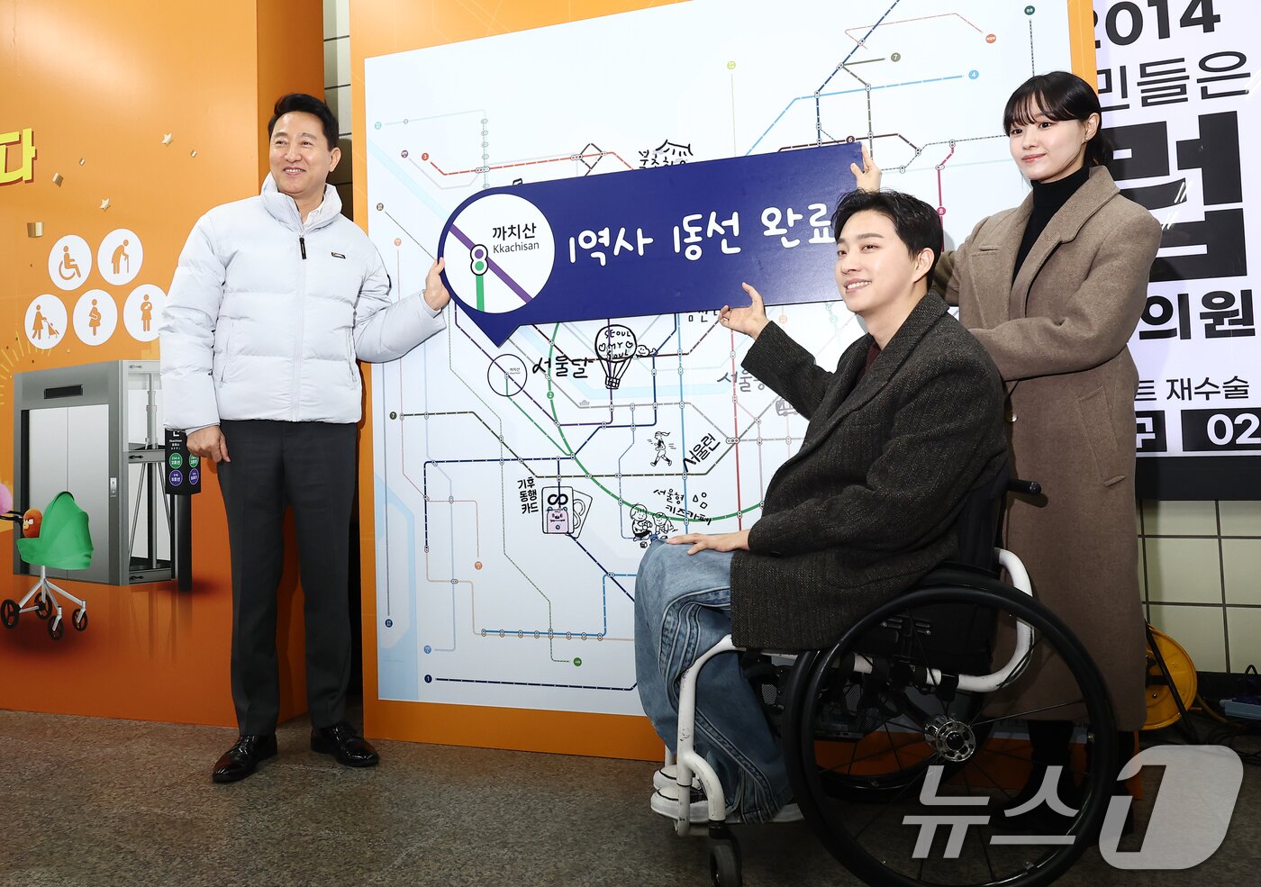 본문 이미지 - 오세훈 서울시장이 29일 오후 서울 강서구 까치산역에서 열린 전역사 1역사 1동선 확보 기념행사에서 가수 송지은, 박위 부부와 함께 1역사 1동선 완료 피켓을 들고 기념촬영을 하고 있다. 2025.12.29 ⓒ 뉴스1 김민지 기자